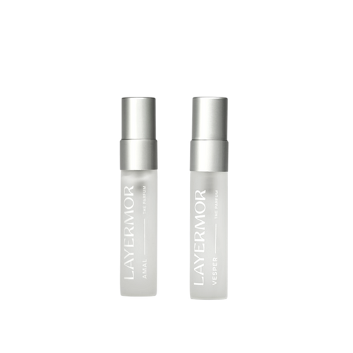 Two LAYERMOR cosmetic bottles, one labeled AMAL and the other VERBIE, standing upright against a plain white background.
